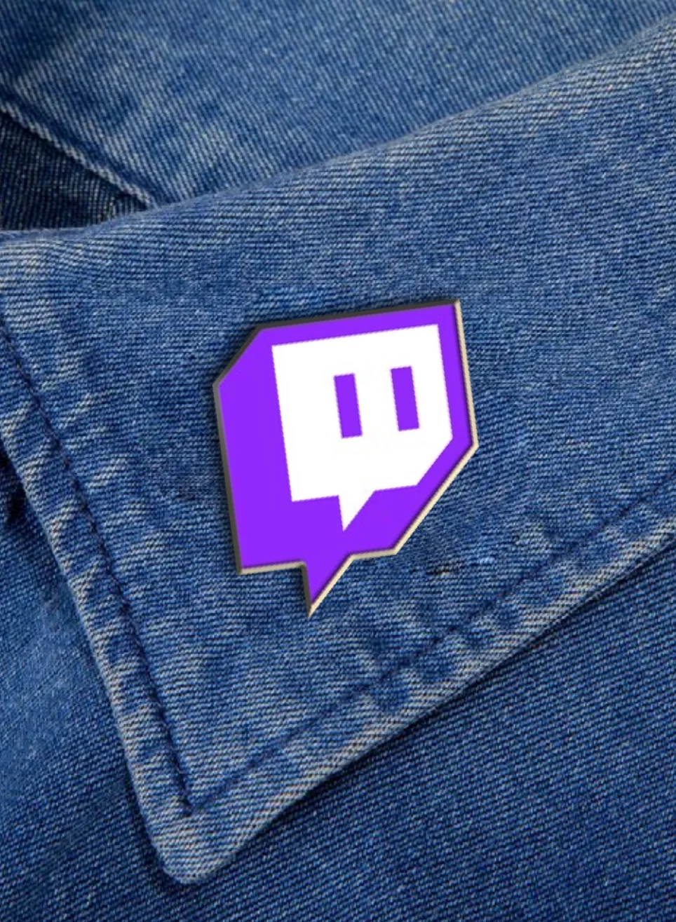 An enamel Glitch pin on a denim jacket collar